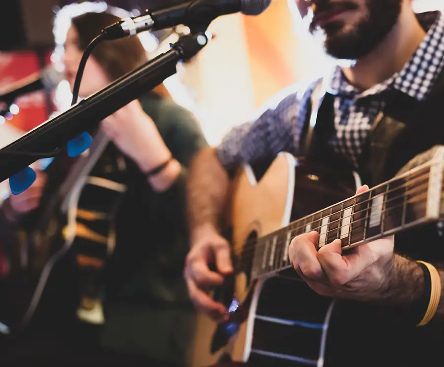 two people playing the guitar